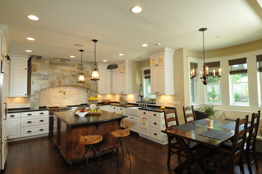 Mountain style l-shaped eat-in kitchen photo in Chicago with a farmhouse sink, raised-panel cabinets and white cabinets