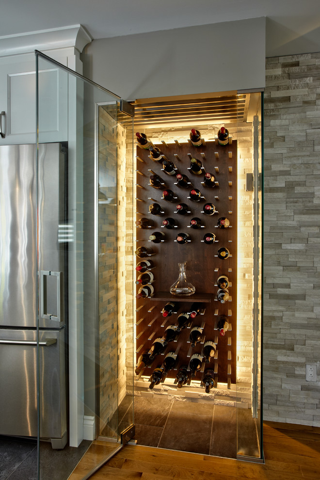 Photo of a small modern wine cellar in Montreal with ceramic floors and display racks.