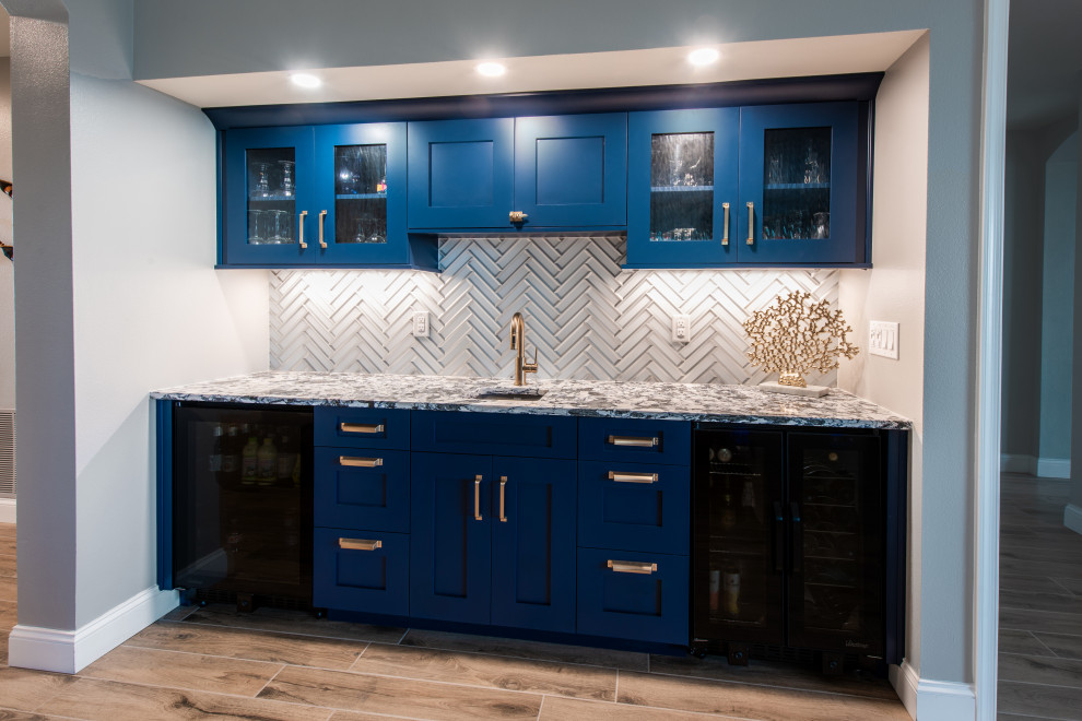 Design ideas for a mid-sized beach style single-wall wet bar in Orlando with an undermount sink, shaker cabinets, blue cabinets, quartz benchtops, grey splashback, mirror splashback, porcelain floors, beige floor and blue benchtop.