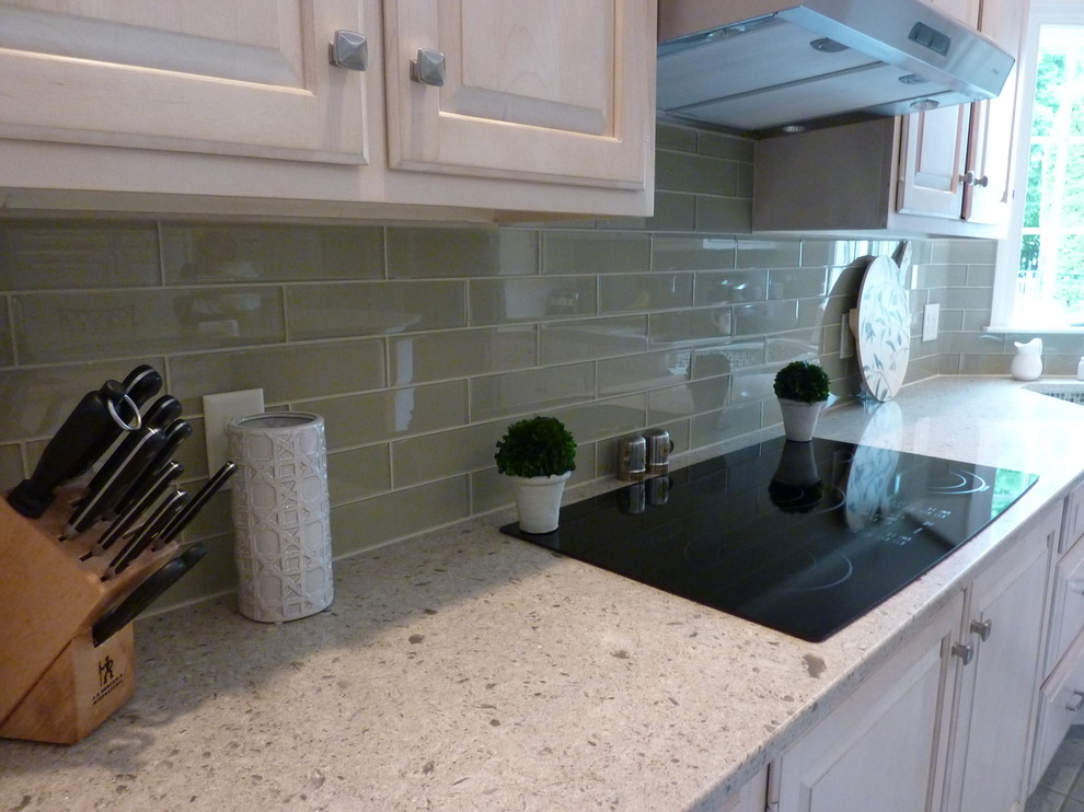 Example of a large transitional l-shaped ceramic tile eat-in kitchen design with an undermount sink, raised-panel cabinets, light wood cabinets, quartzite countertops, beige backsplash, glass tile backsplash, stainless steel appliances and an island