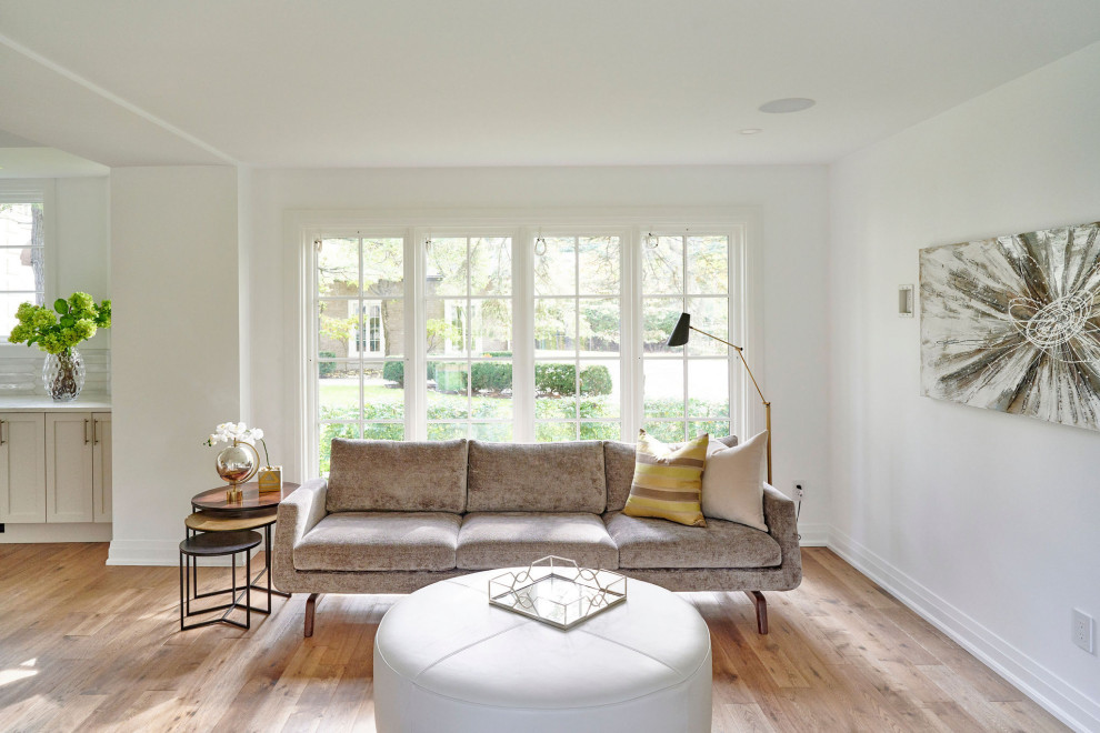 Réalisation d'une salle de séjour design avec un mur blanc, un sol en bois brun, aucun téléviseur et un sol marron.