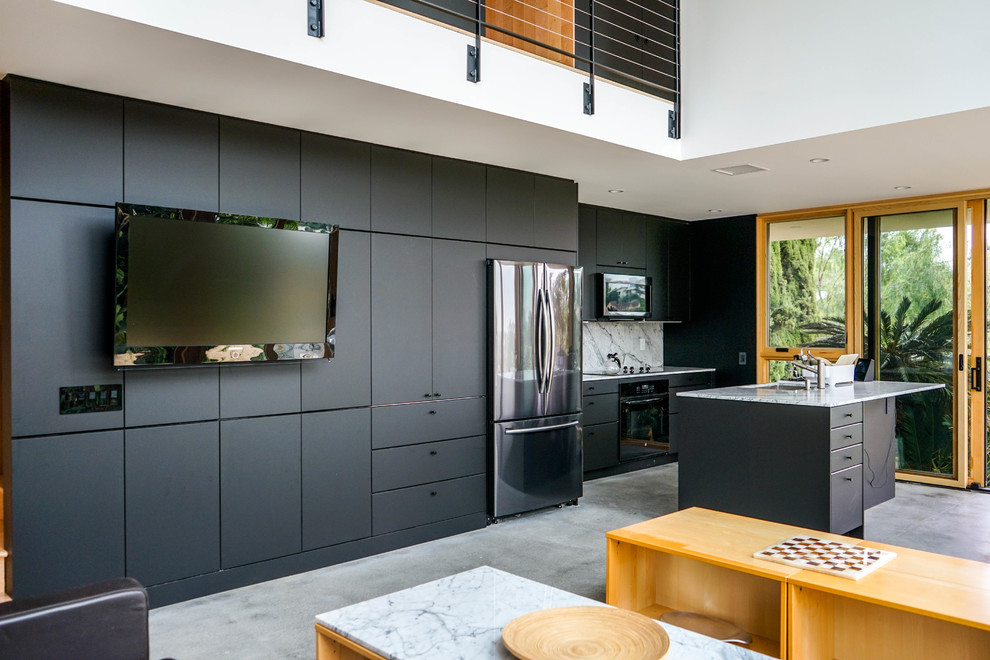 Photo of a mid-sized modern single-wall open plan kitchen in Los Angeles with a double-bowl sink, flat-panel cabinets, black cabinets, grey splashback, marble splashback, stainless steel appliances, with island, grey floor, grey benchtop, quartz benchtops, cement tiles and vaulted.