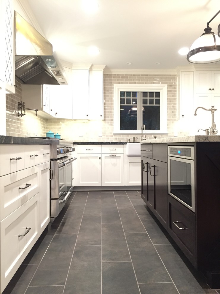 Large transitional kitchen in Los Angeles with a farmhouse sink, shaker cabinets, white cabinets, marble benchtops, beige splashback, subway tile splashback, stainless steel appliances, ceramic floors and with island.