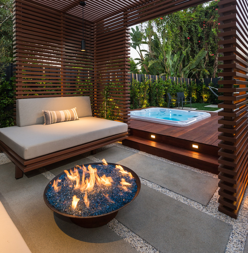 Photo of a small contemporary backyard patio in Los Angeles with a fire feature and a pergola.
