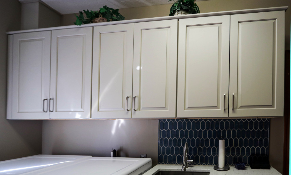 Klassisk inredning av en liten vita linjär vitt tvättstuga enbart för tvätt, med en undermonterad diskho, luckor med upphöjd panel, vita skåp, bänkskiva i kvarts, blått stänkskydd, stänkskydd i cementkakel, grå väggar och en tvättmaskin och torktumlare bredvid varandra