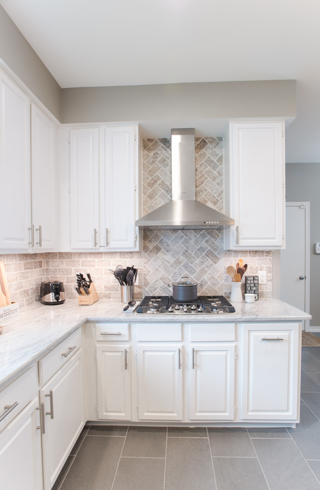 Mid-sized transitional u-shaped eat-in kitchen in Dallas with an undermount sink, raised-panel cabinets, white cabinets, quartzite benchtops, grey splashback, stone tile splashback, stainless steel appliances, porcelain floors, with island, grey floor and white benchtop.