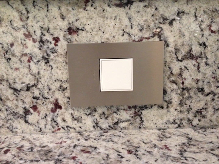 Mid-sized transitional l-shaped light wood floor eat-in kitchen photo with an undermount sink, recessed-panel cabinets, white cabinets, granite countertops, white backsplash, stone tile backsplash, white appliances and a peninsula