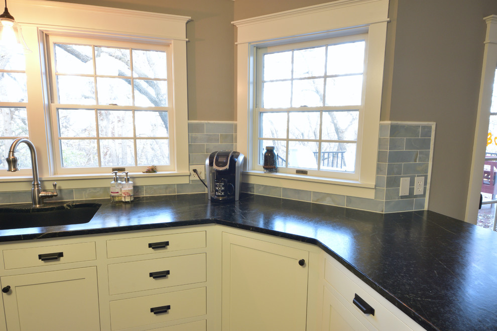 Photo of a country u-shaped eat-in kitchen in Other with an undermount sink, beaded inset cabinets, white cabinets, soapstone benchtops, blue splashback, stone tile splashback, stainless steel appliances, slate floors and with island.