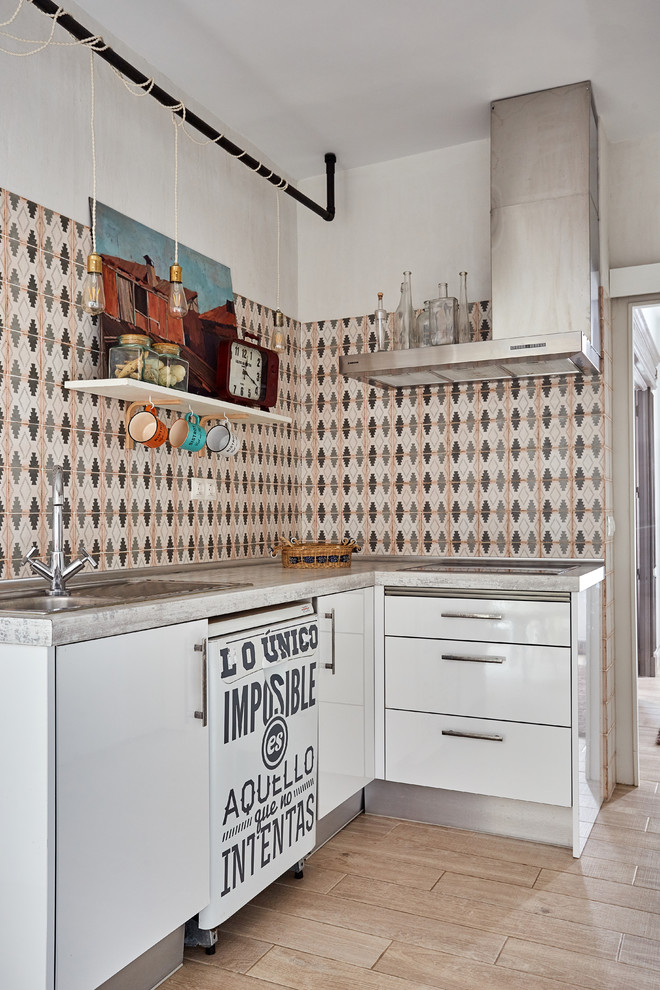 Small mediterranean l-shaped kitchen in Madrid with a double-bowl sink, flat-panel cabinets, white cabinets, multi-coloured splashback, ceramic splashback, no island, stainless steel benchtops and beige floor.