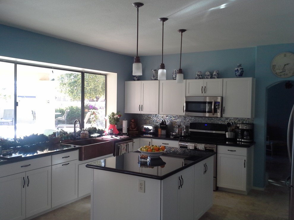Mid-sized transitional l-shaped ceramic tile and beige floor kitchen photo in Phoenix with a farmhouse sink, metal backsplash, stainless steel appliances, metallic backsplash, shaker cabinets, white cabinets, laminate countertops and an island