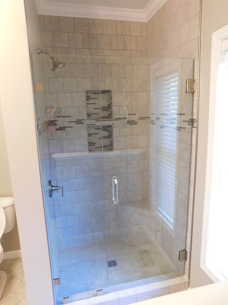 Corner bathtub - large transitional master gray tile and ceramic tile ceramic tile corner bathtub idea with raised-panel cabinets, medium tone wood cabinets, a two-piece toilet, beige walls, an undermount sink and granite countertops