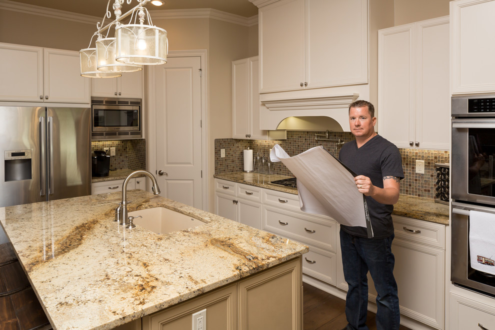 Open concept kitchen - mid-sized transitional l-shaped dark wood floor and brown floor open concept kitchen idea with an undermount sink, recessed-panel cabinets, white cabinets, granite countertops, multicolored backsplash, mosaic tile backsplash, stainless steel appliances and an island