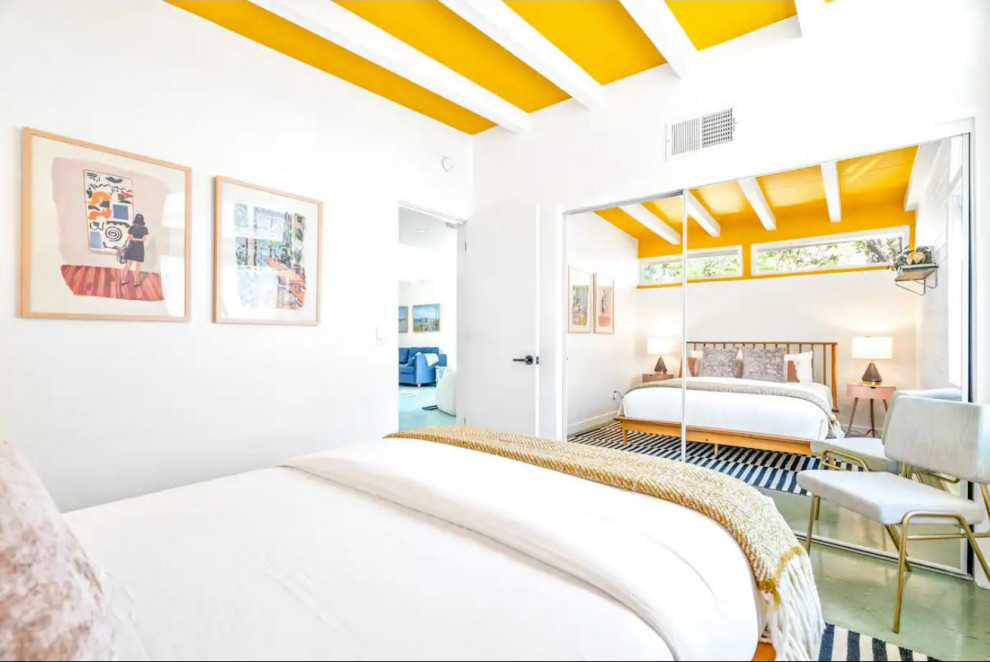 Idee per una camera degli ospiti moderna con pareti bianche, pavimento in laminato, pavimento verde, travi a vista e pareti in mattoni