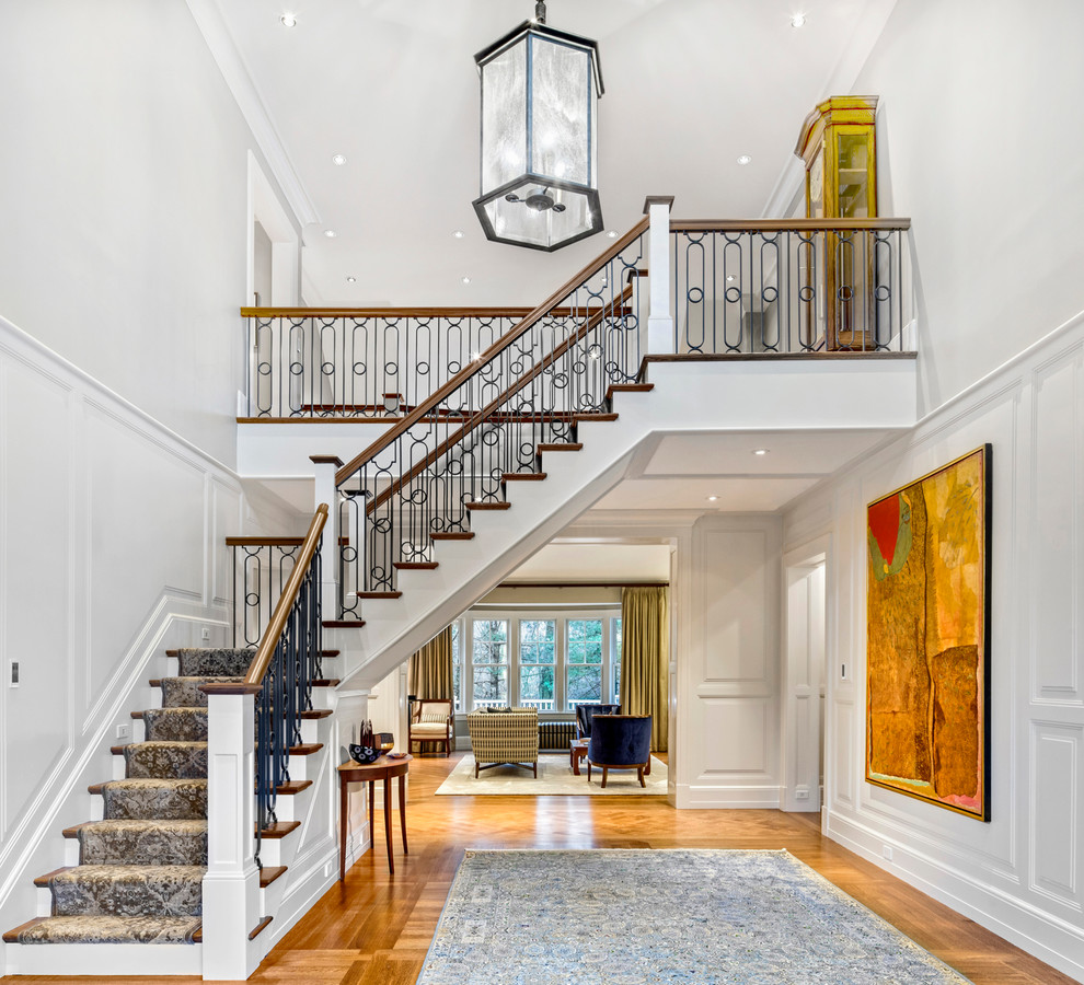 Photo of an expansive traditional foyer in Boston with white walls, medium hardwood floors and a double front door.