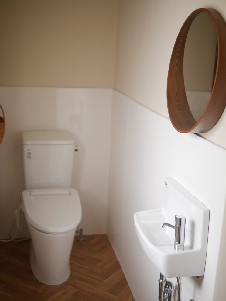 This is an example of a scandinavian powder room in Osaka with white cabinets, a one-piece toilet, white tile, white walls, plywood floors, brown floor and a freestanding vanity.