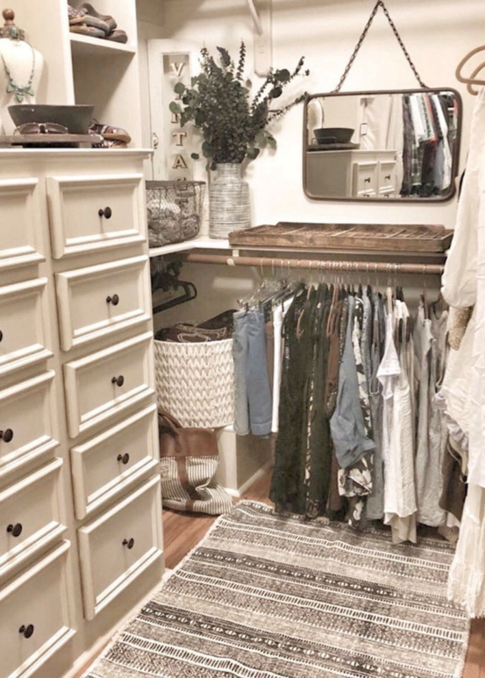 Photo of a small eclectic women's walk-in wardrobe in Houston with light hardwood floors and brown floor.