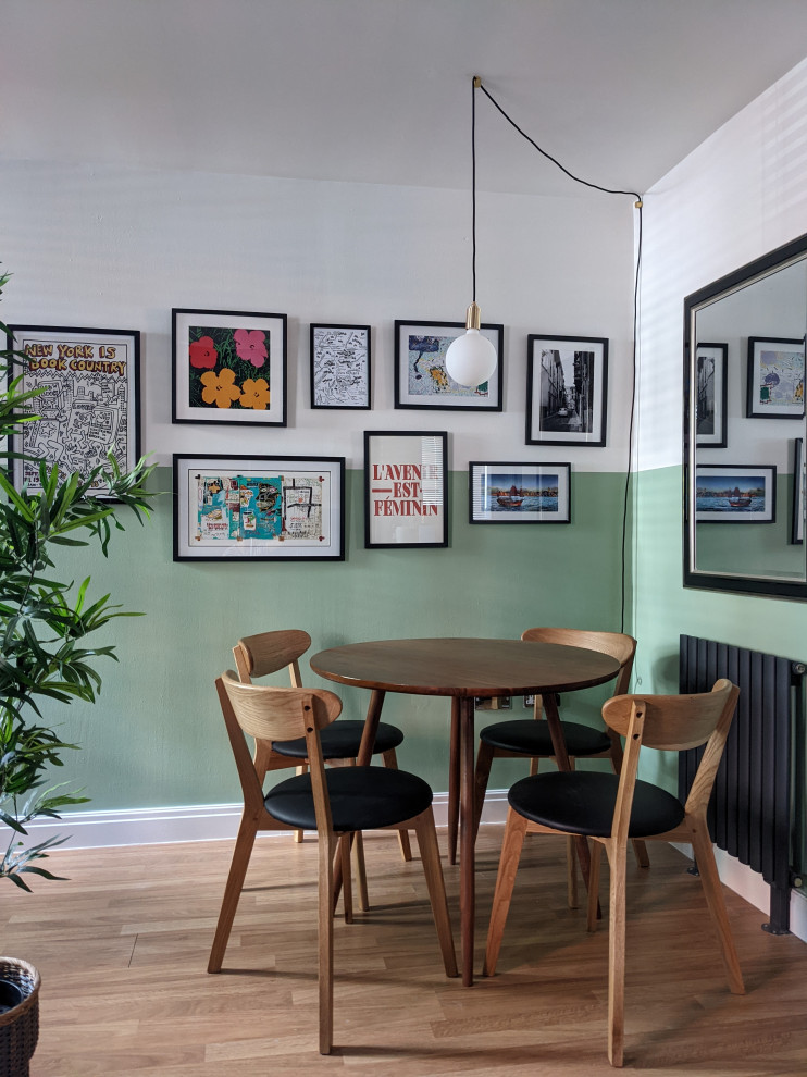 Idée de décoration pour une salle à manger ouverte sur le salon bohème de taille moyenne avec un mur vert et sol en stratifié.
