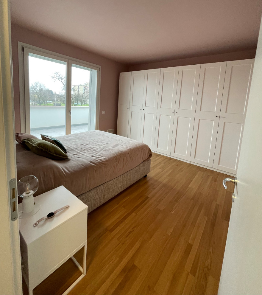 Photo of a mid-sized contemporary master bedroom in Other with pink walls, medium hardwood floors and brown floor.