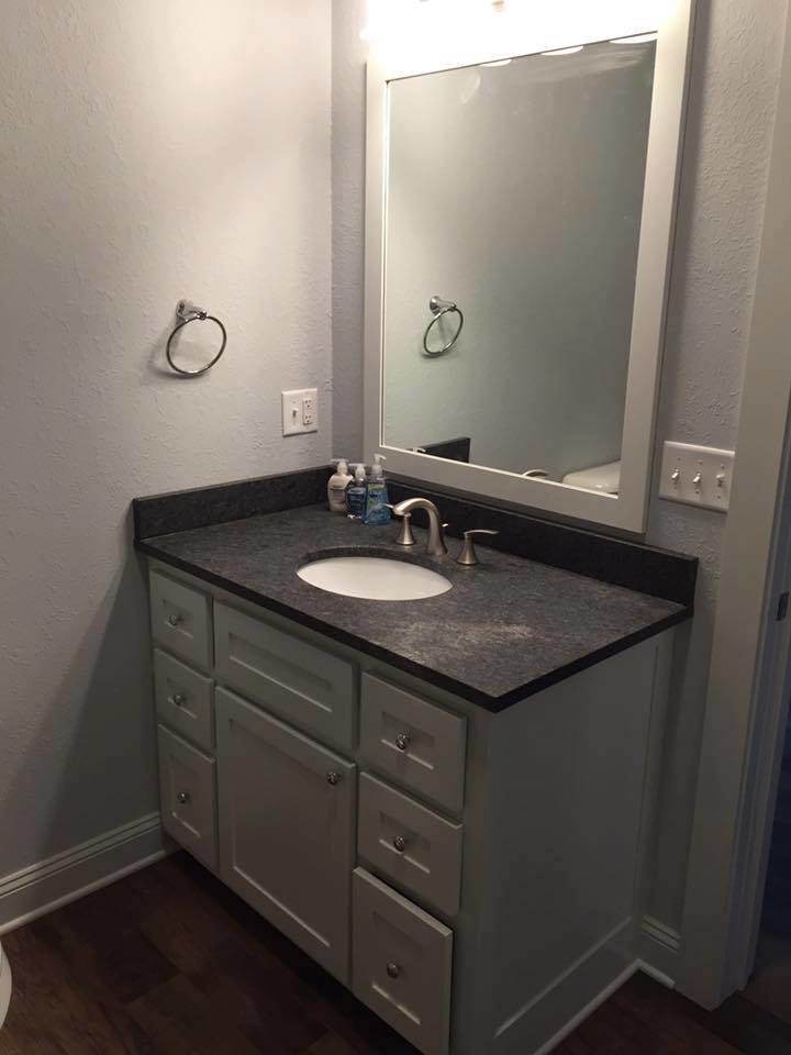 This is an example of a small transitional bathroom in Chicago with shaker cabinets, grey cabinets, brown walls, dark hardwood floors, an undermount sink, recycled glass benchtops and brown floor.