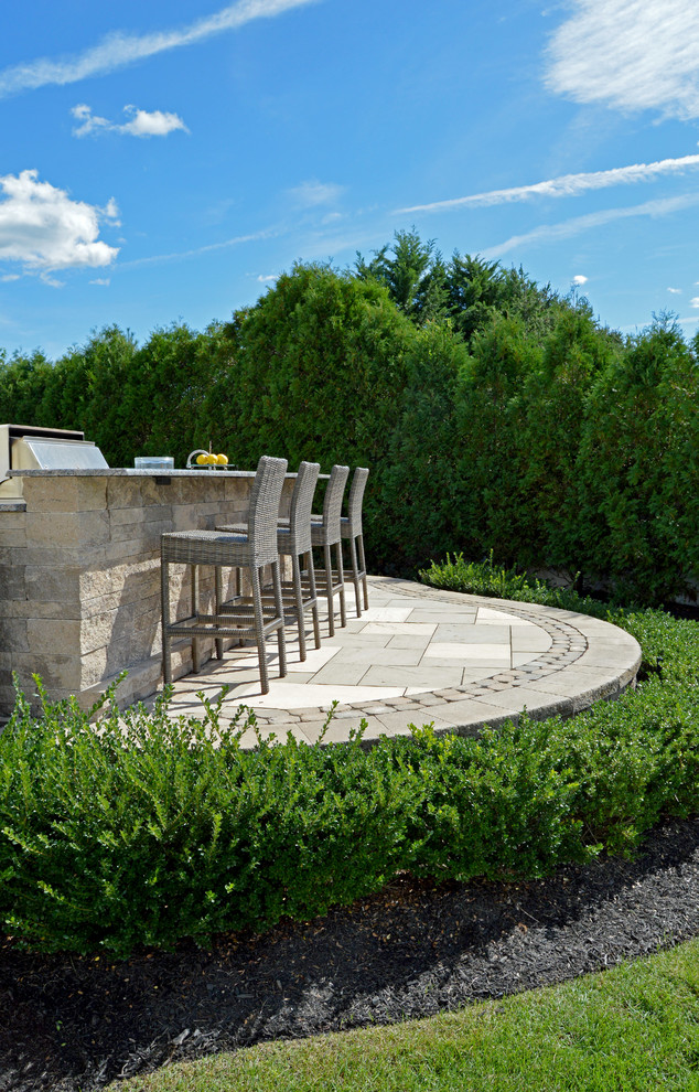 Photo of a traditional backyard patio in New York with an outdoor kitchen and concrete pavers.