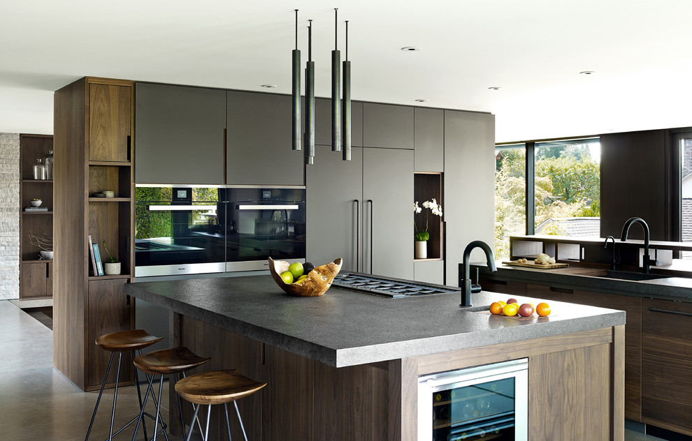 Design ideas for a contemporary kitchen in Seattle with an undermount sink, flat-panel cabinets, black cabinets, black appliances and multiple islands.