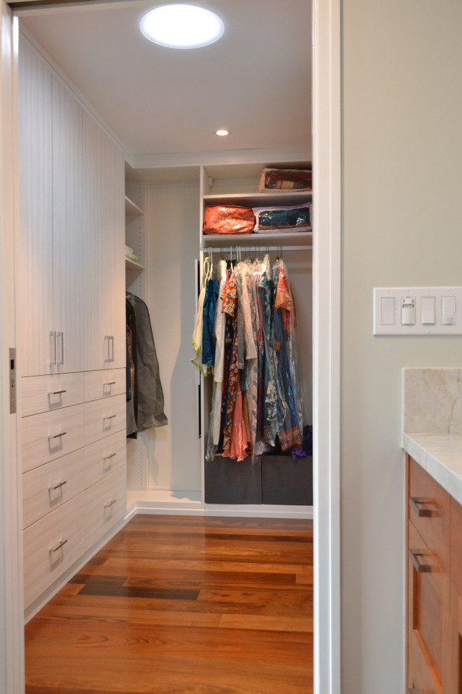 Design ideas for a mid-sized transitional storage and wardrobe in San Francisco with ceramic floors, grey floor, recessed-panel cabinets and medium wood cabinets.