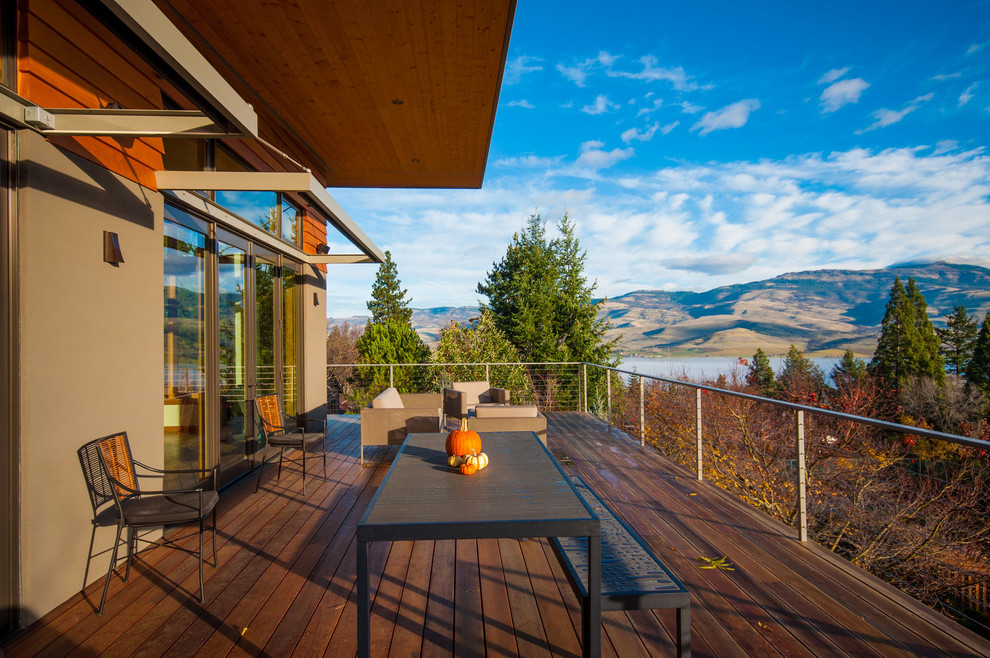 Mid-sized trendy deck photo with a roof extension