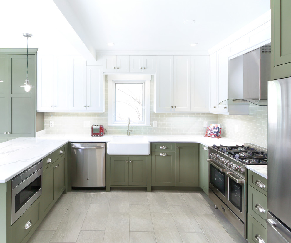 Inspiration for a mid-sized contemporary u-shaped eat-in kitchen in Louisville with a farmhouse sink, recessed-panel cabinets, green cabinets, quartzite benchtops, green splashback, subway tile splashback, stainless steel appliances, porcelain floors, a peninsula, beige floor and white benchtop.