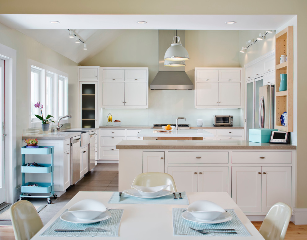Design ideas for a contemporary u-shaped open plan kitchen in San Diego with a farmhouse sink, shaker cabinets, white cabinets, white splashback, glass sheet splashback and stainless steel appliances.