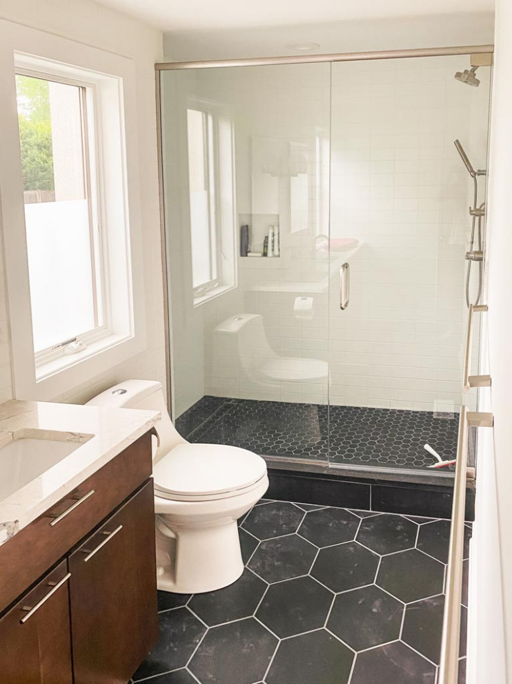 Contemporary master bathroom in Cleveland with flat-panel cabinets, medium wood cabinets, an alcove shower, white tile, ceramic tile, white walls, ceramic floors, an undermount sink, marble benchtops, black floor, a hinged shower door, white benchtops, a niche, a double vanity and a floating vanity.
