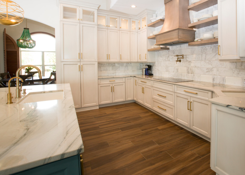 Design ideas for a large transitional galley eat-in kitchen in Orlando with an undermount sink, recessed-panel cabinets, white cabinets, quartzite benchtops, grey splashback, marble splashback, stainless steel appliances, porcelain floors, with island, brown floor and white benchtop.