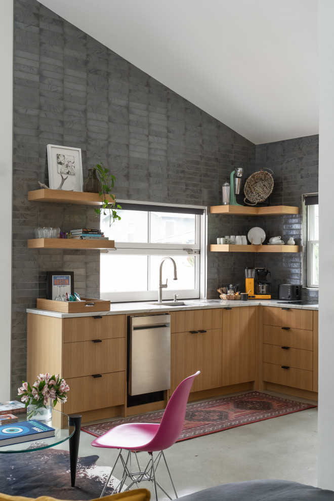 Open concept kitchen - small contemporary l-shaped concrete floor, gray floor and vaulted ceiling open concept kitchen idea in Austin with an undermount sink, flat-panel cabinets, medium tone wood cabinets, quartzite countertops, gray backsplash, glass tile backsplash, stainless steel appliances, no island and white countertops