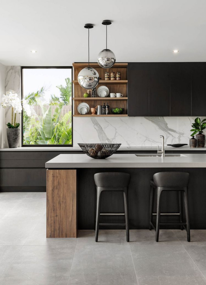Inspiration for a large contemporary galley open plan kitchen in Columbus with an undermount sink, flat-panel cabinets, black cabinets, quartzite benchtops, white splashback, marble splashback, stainless steel appliances, with island, grey floor and grey benchtop.