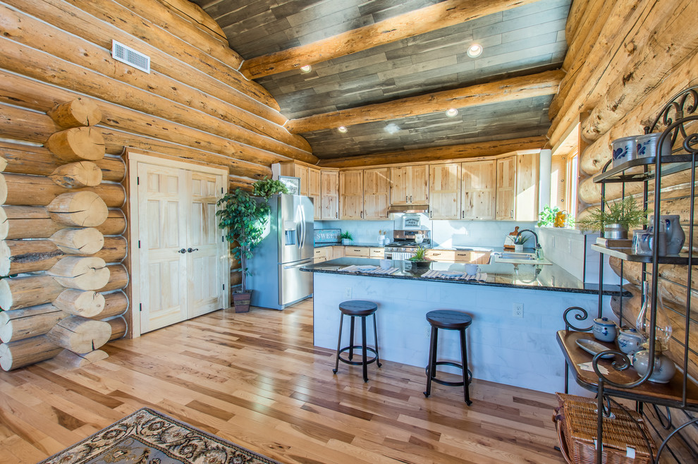 Inspiration for a large rustic u-shaped enclosed kitchen remodel in Denver with a double-bowl sink, shaker cabinets, light wood cabinets, granite countertops, gray backsplash, porcelain backsplash, stainless steel appliances and brown countertops
