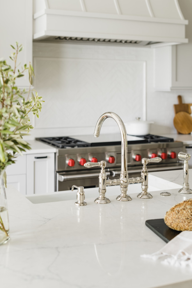 Eat-in kitchen - large transitional medium tone wood floor eat-in kitchen idea in Charlotte with a farmhouse sink, shaker cabinets, gray cabinets, quartz countertops, white backsplash, porcelain backsplash, stainless steel appliances, an island and white countertops