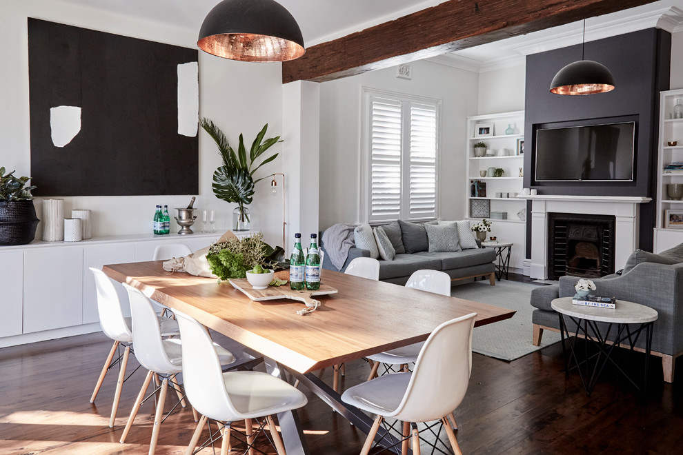 Inspiration for a mid-sized transitional open plan dining in Sydney with white walls, dark hardwood floors, a standard fireplace, a wood fireplace surround and brown floor.