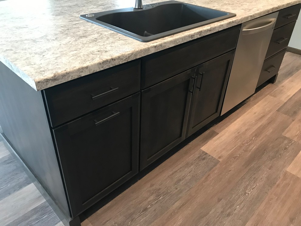 Photo of a large transitional galley open plan kitchen in Cedar Rapids with a double-bowl sink, shaker cabinets, dark wood cabinets, laminate benchtops, stainless steel appliances, with island and grey benchtop.