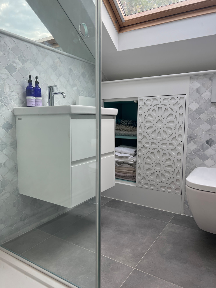 Cette image montre une petite salle de bain bohème avec un carrelage gris, meuble simple vasque et meuble-lavabo suspendu.