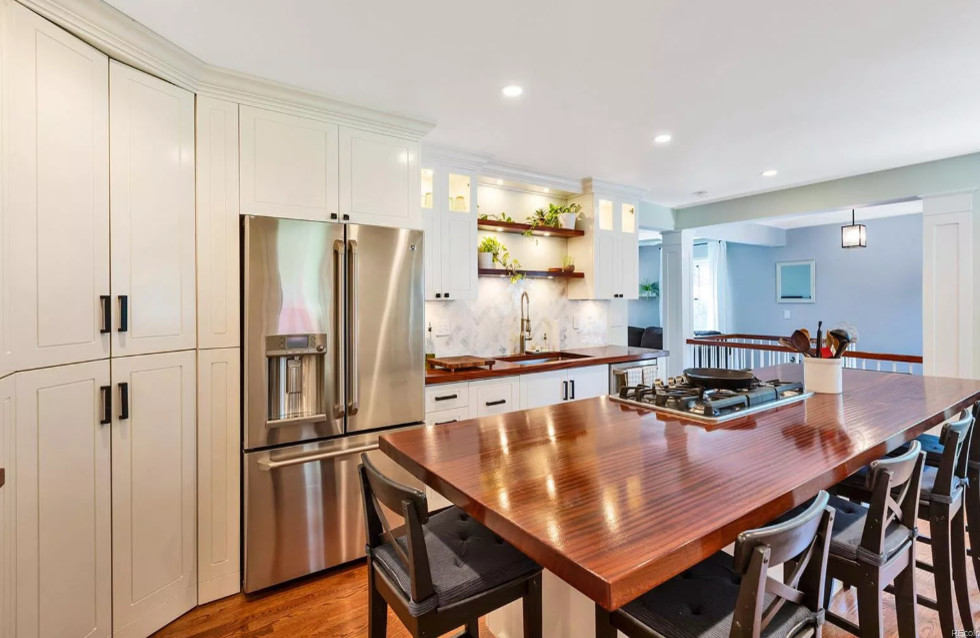 Example of a mid-sized transitional u-shaped dark wood floor and brown floor eat-in kitchen design in Denver with an undermount sink, recessed-panel cabinets, white cabinets, wood countertops, white backsplash, marble backsplash, stainless steel appliances, an island and brown countertops