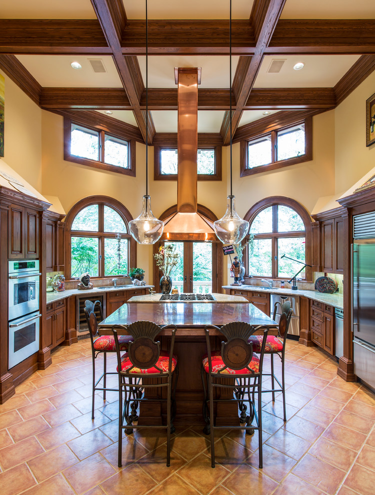 Inspiration for a mediterranean u-shaped separate kitchen in Little Rock with raised-panel cabinets and dark wood cabinets.