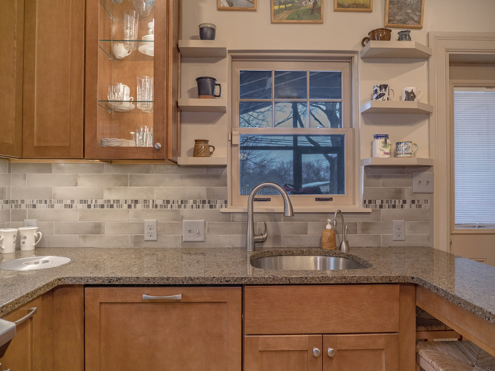 Mid-sized u-shaped medium tone wood floor and brown floor enclosed kitchen photo in DC Metro with an undermount sink, recessed-panel cabinets, brown cabinets, gray backsplash, ceramic backsplash, stainless steel appliances, no island, granite countertops and brown countertops