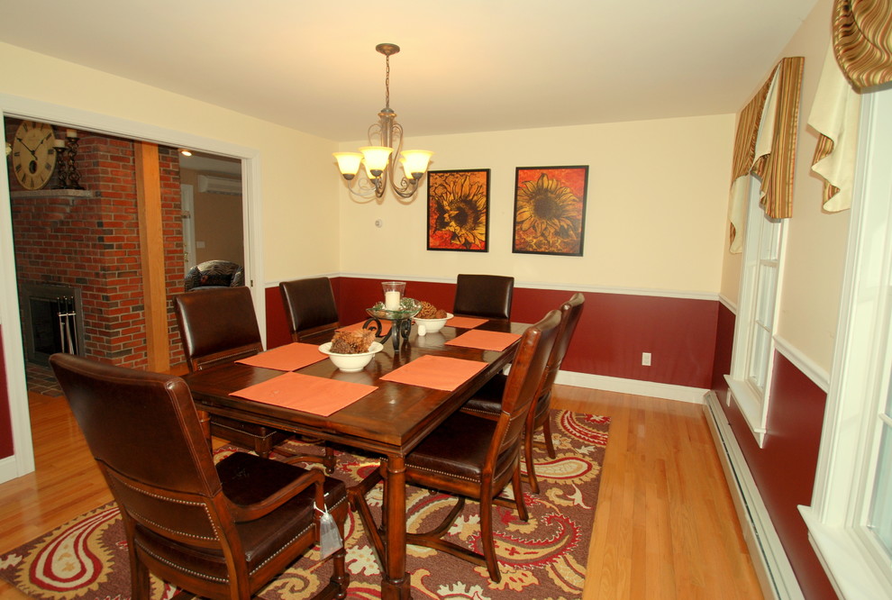 Inspiration for a mid-sized transitional separate dining room in Manchester with red walls and light hardwood floors.