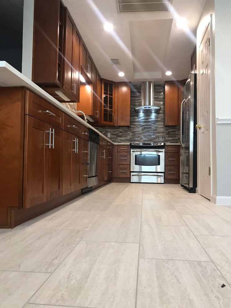 Mid-sized transitional u-shaped porcelain tile and gray floor enclosed kitchen photo in Houston with an undermount sink, shaker cabinets, medium tone wood cabinets, quartz countertops, multicolored backsplash, glass tile backsplash, stainless steel appliances, no island and white countertops
