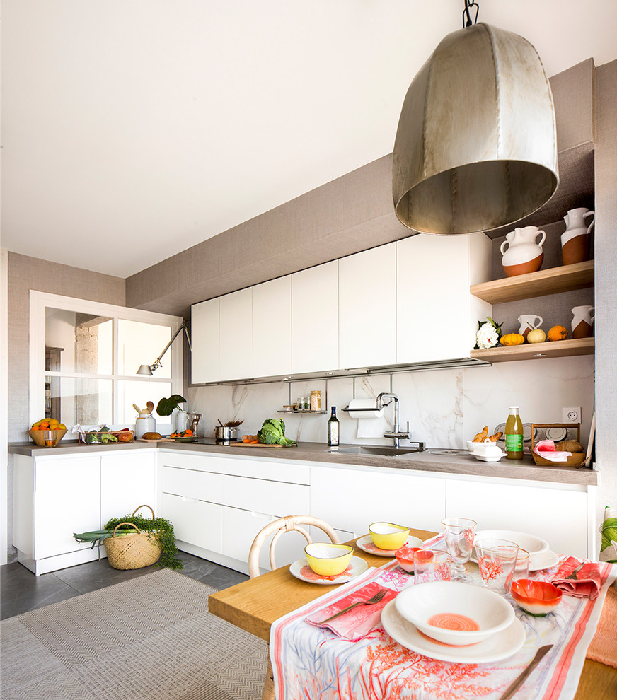 Photo of a mid-sized traditional l-shaped eat-in kitchen in Bilbao with an undermount sink, flat-panel cabinets, white cabinets and no island.