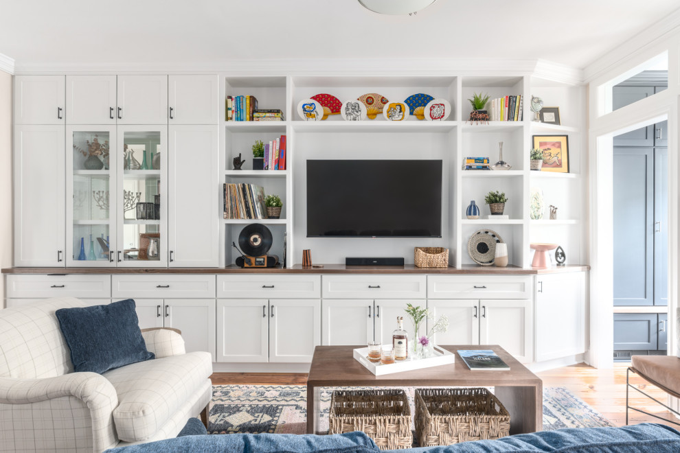Foto de sala de estar tradicional renovada con paredes blancas, suelo de madera en tonos medios, pared multimedia y suelo marrón