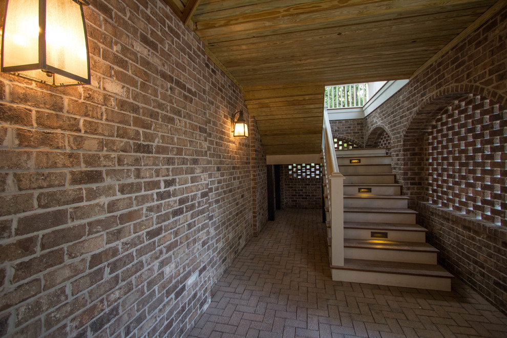 This is an example of a traditional brick back porch design in Charleston.