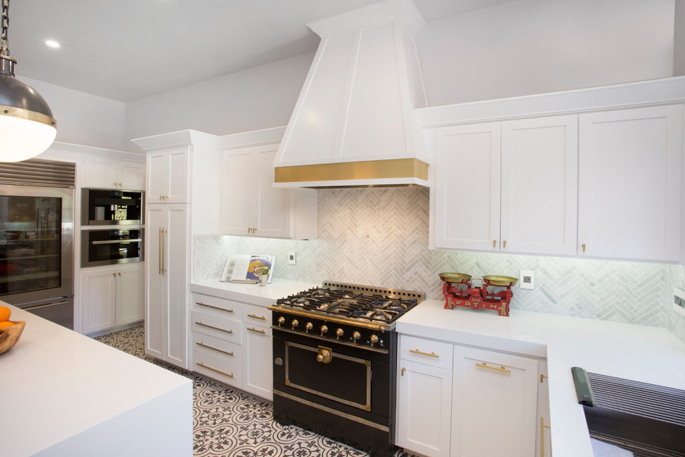 Photo of a mid-sized eclectic u-shaped eat-in kitchen in Los Angeles with an undermount sink, shaker cabinets, white cabinets, quartz benchtops, grey splashback, matchstick tile splashback, black appliances, ceramic floors and with island.