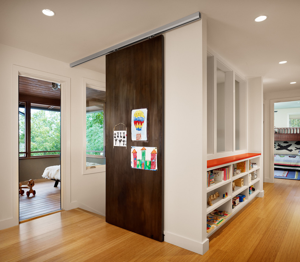 This is an example of a contemporary hallway in Austin with white walls and medium hardwood floors.