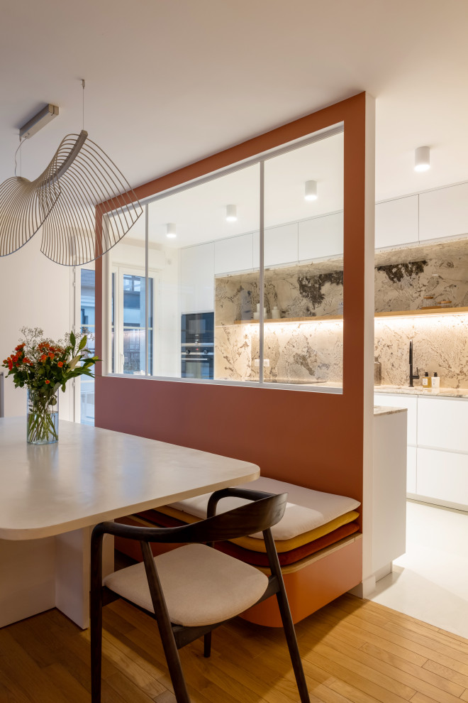 Inspiration pour une grande salle à manger design avec un mur orange, parquet clair, un sol marron et verrière.