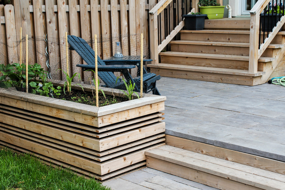 This is an example of a large transitional backyard full sun garden in Ottawa with a vegetable garden and decking.